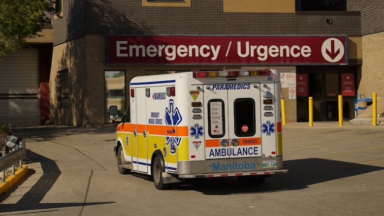 An ambulance outside a building with a sign reading "Emergency."