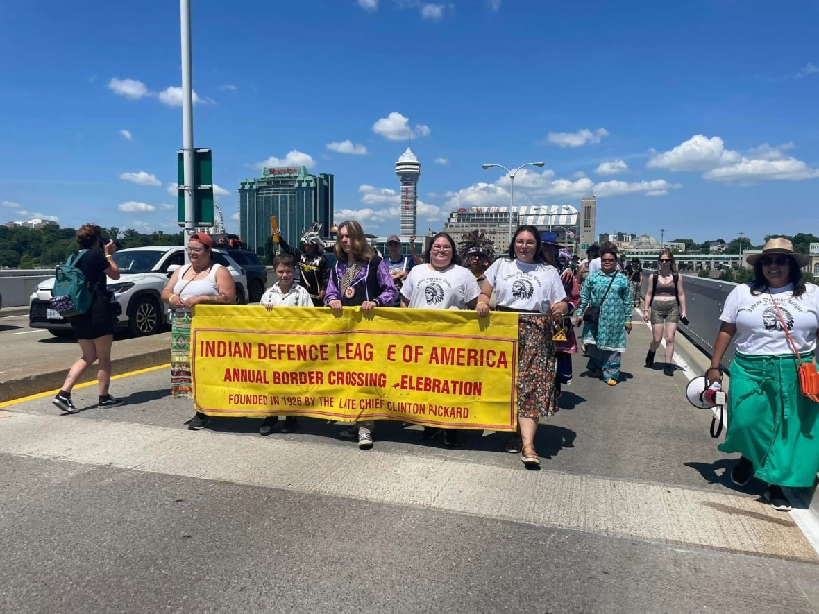 Photo of Indigenous people crossing the bridge at Niagara Falls.