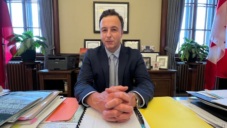 A man in a suit sitting at his desk.