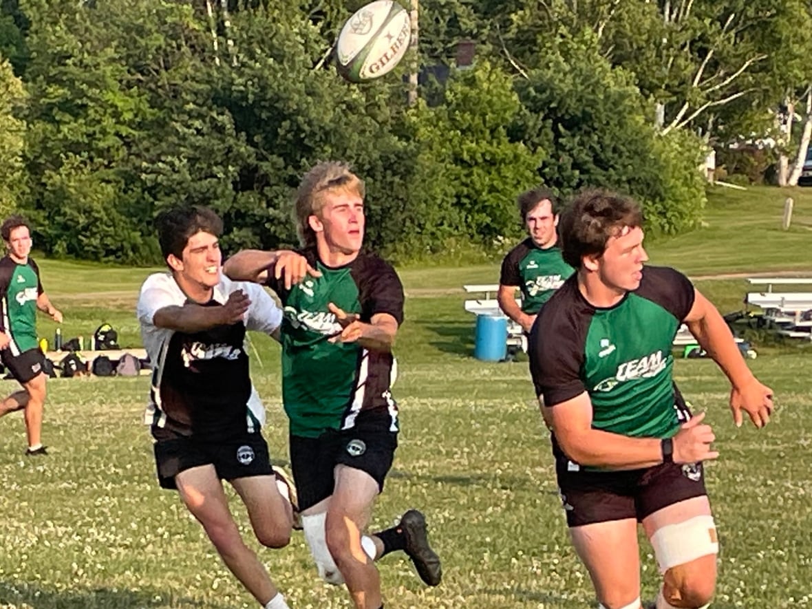 3 men running after a rugby ball