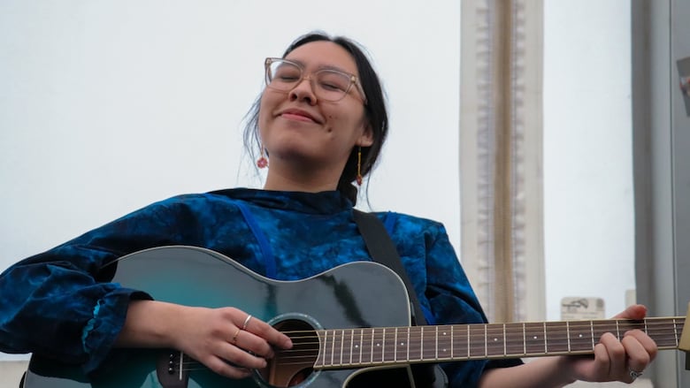 A woman playing guitar.
