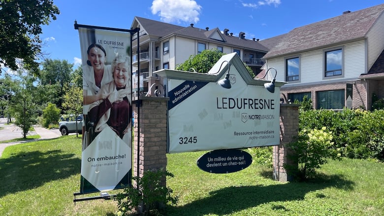 A house is seen with a big sign in front showing it is a care facility for seniors.