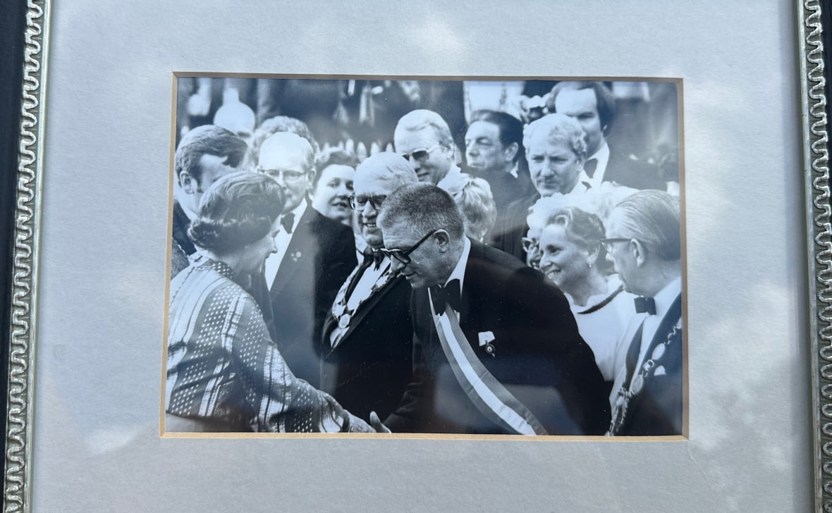 Jack Edwards is pictured in this framed photo looking on (back right) as Queen Elizabeth II greets the Windsor, Ont. delegation during a 25th anniversary celebration of her coronation.
