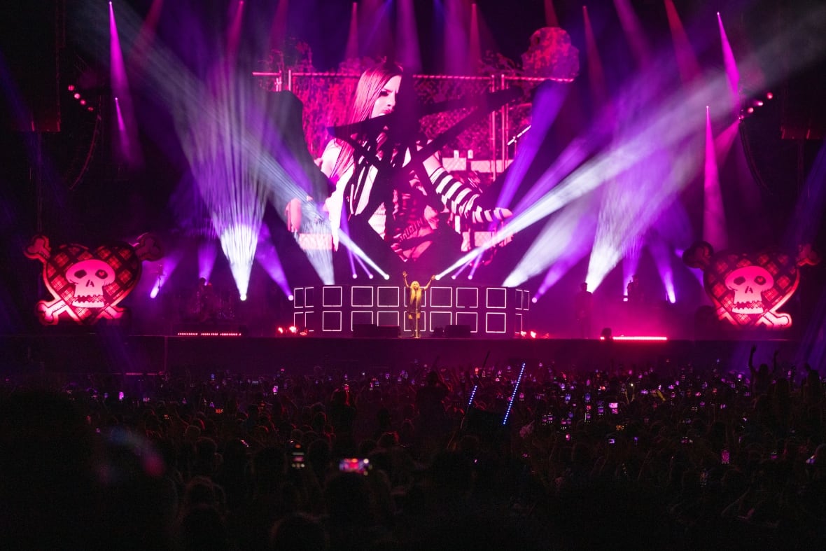 Avril Lavigne performing in front of a large crowd