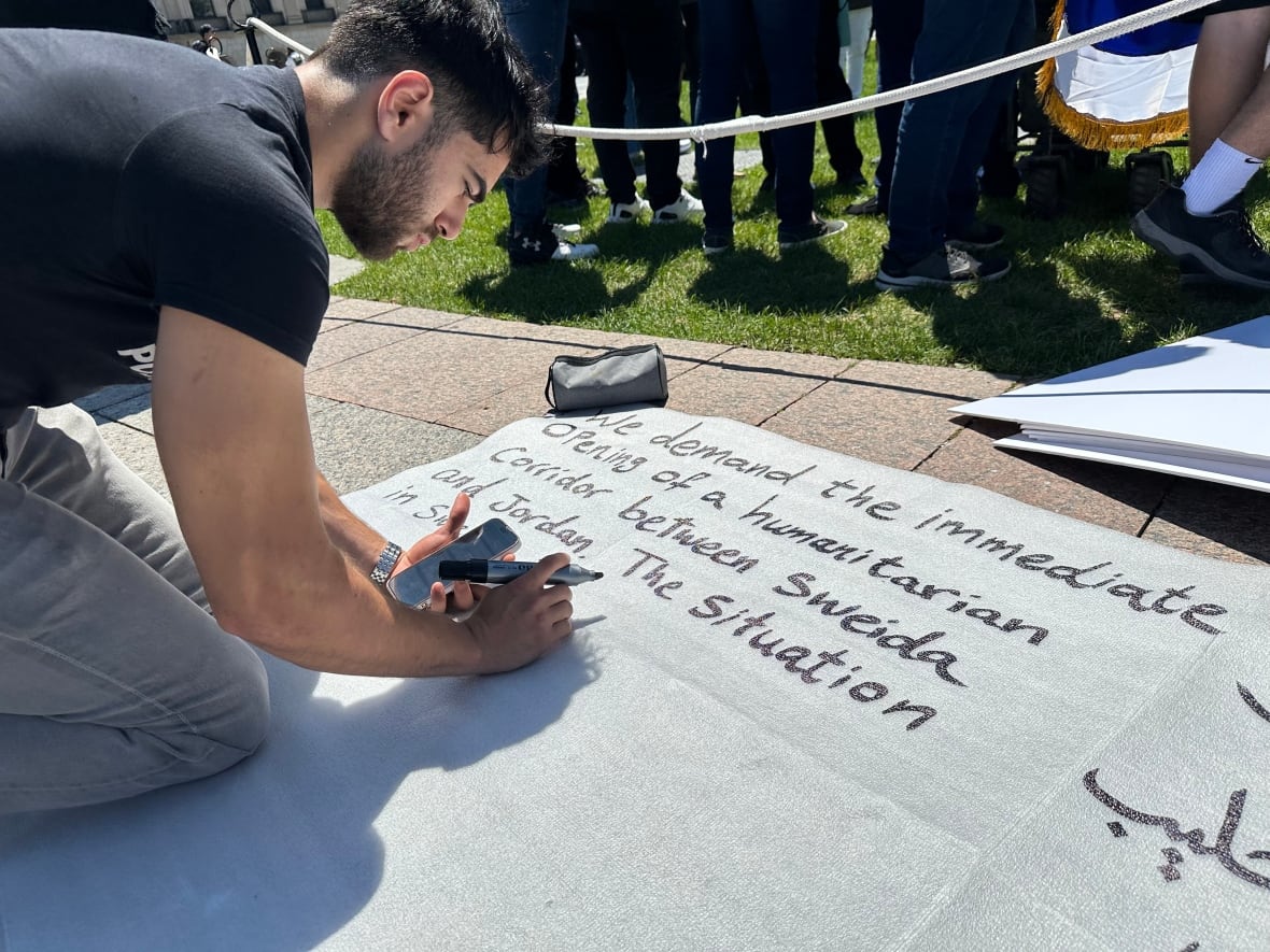 A man writes a sign. 