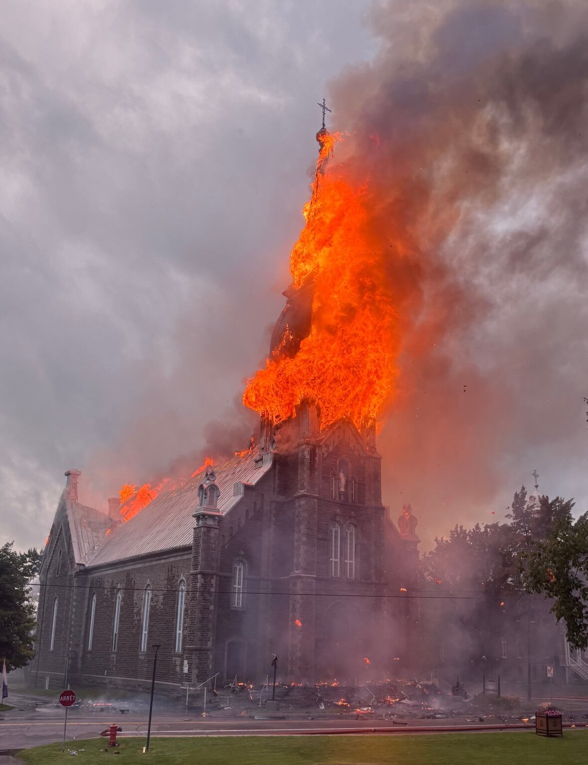 A church on fire. The spire is engulfed in flames.