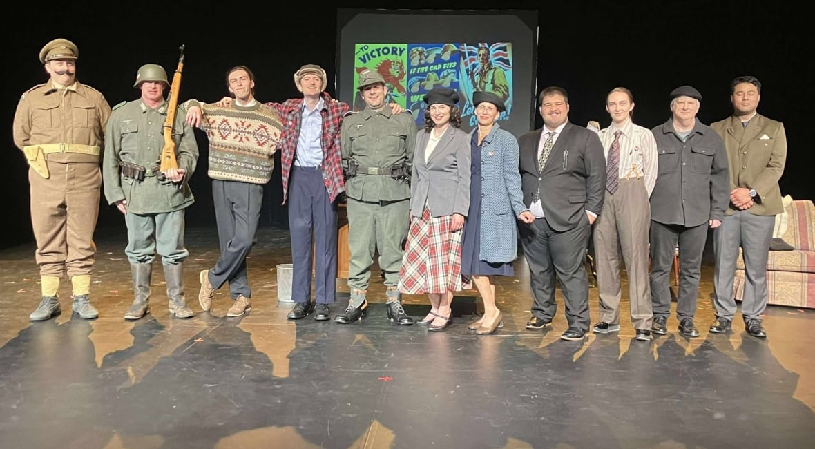 An ensemble cast in a play stand on a stage.