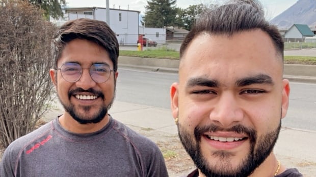 Photo of two men standing in the street.