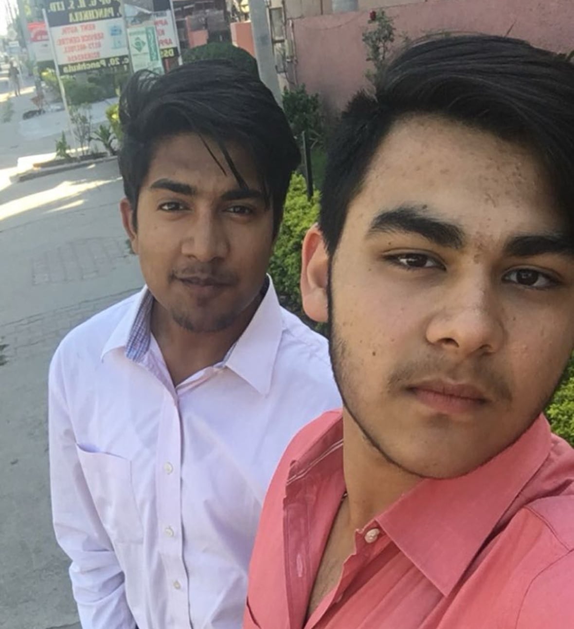 Photo of two young friends standing in the street.