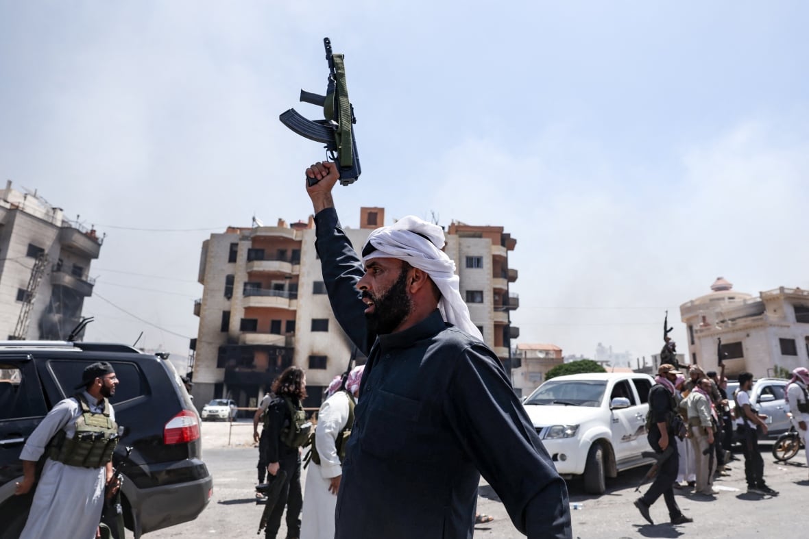 A person raises a rifle above their head.