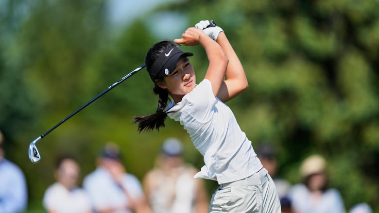 A female golfer hits off the tee.