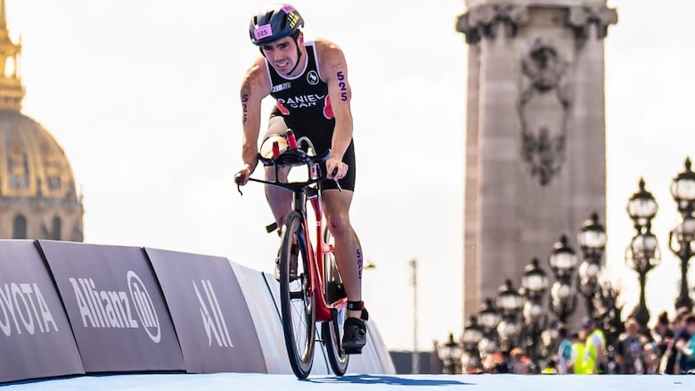 A male Para triathlete bikes during a competition.