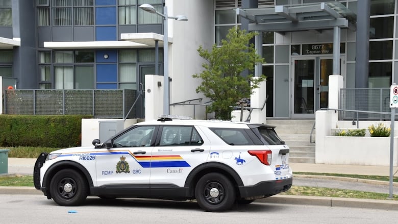 A Richmond RCMP SUV parked outside of a highrise tower