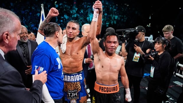 Two male boxers hold up each other