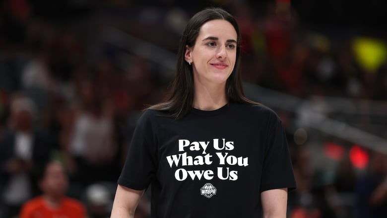 A women's basketball player is seen before a game wearing a short that says 'Pay Us What You Owe Us'.