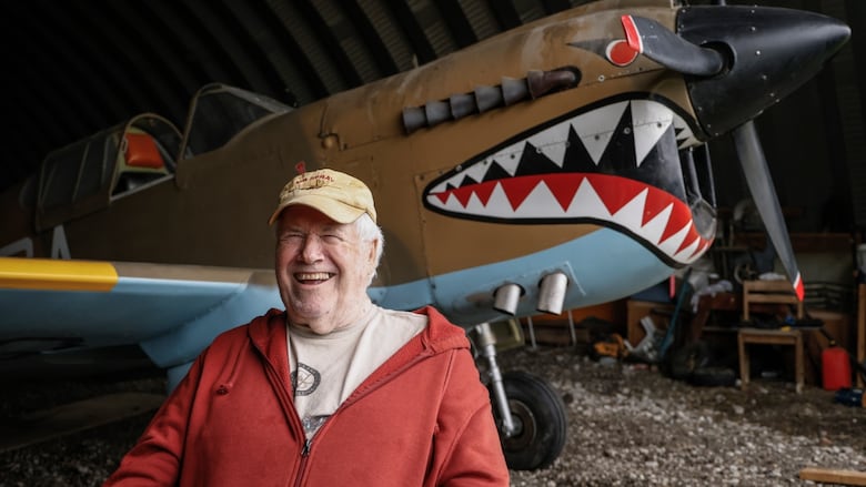 A man in front of a replica plane.