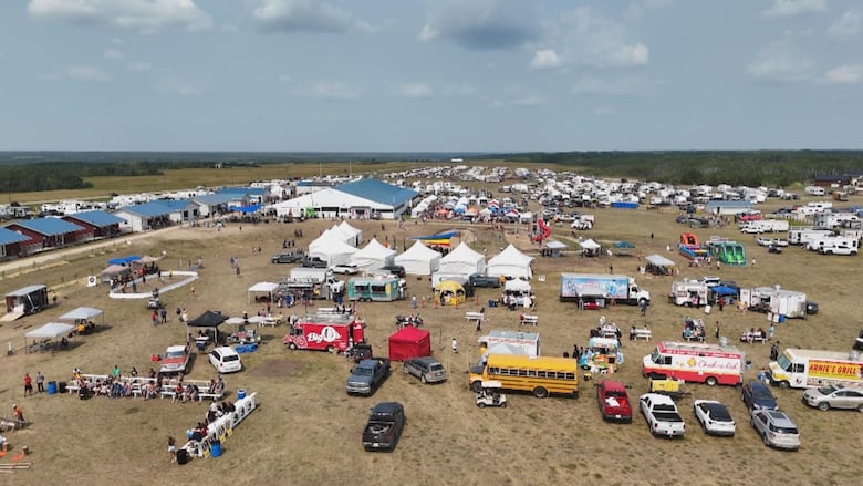 Drone shot of hundreds of trailers and tents arranged at an outdoor festival.