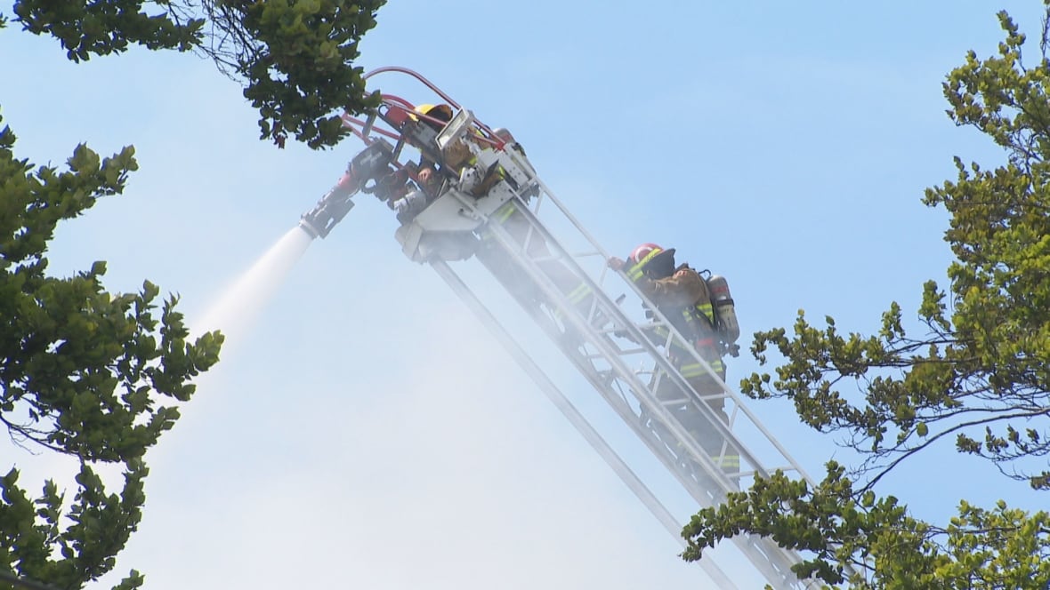 Firefighters use an aerial ladder to douse flames from above as they battle the fire.