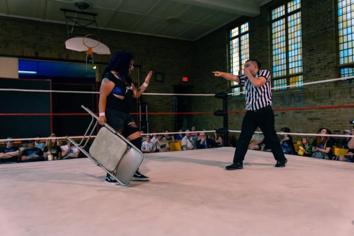 A wrestler and referee in the ring.