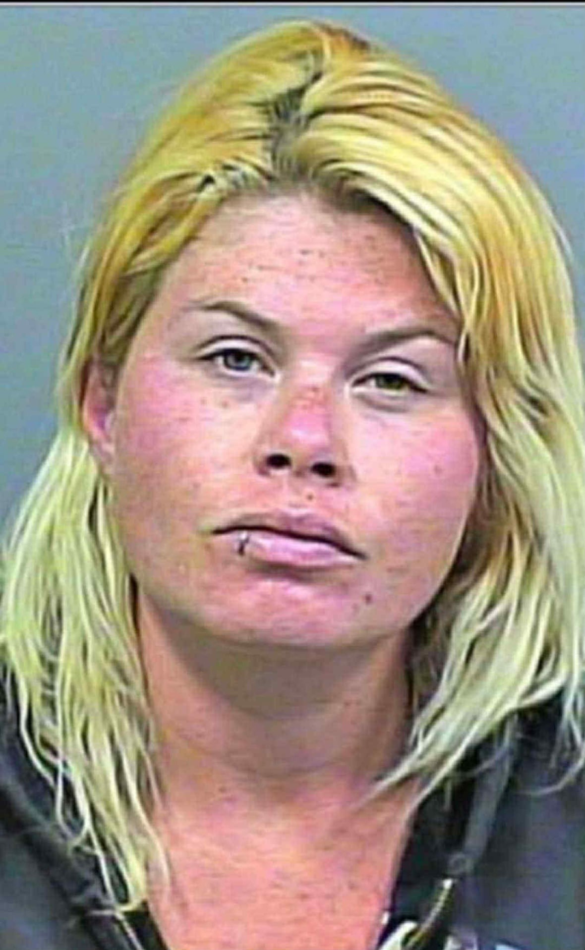 A close-up of a blonde woman with a lip ring.