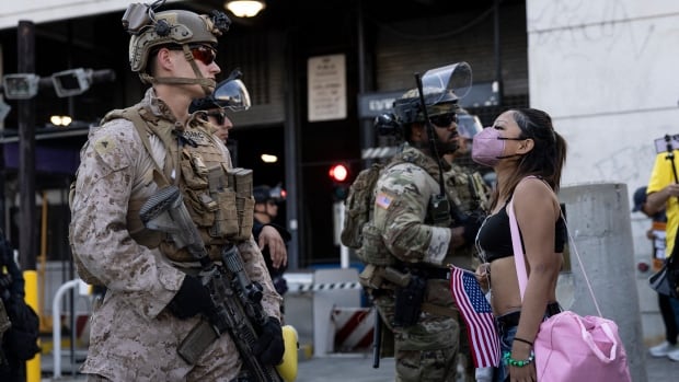 A demonstrator faces a U.S. Marine standing guard as they protest in L.A. in July 2025.