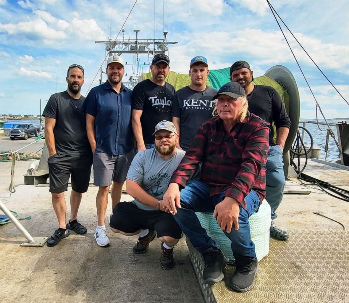 A group of seven men on a boat.