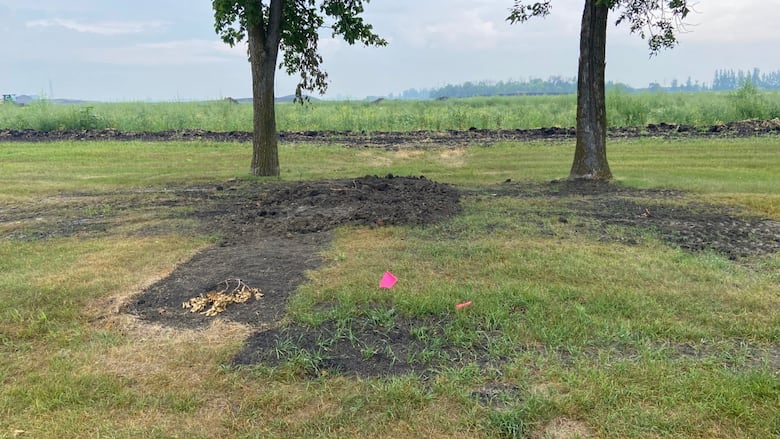 A pile of mud overtop of a plot in Green Acres Cemetery.