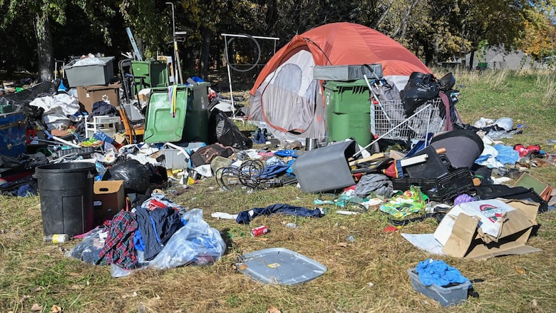 A tent surrounded by garbage.