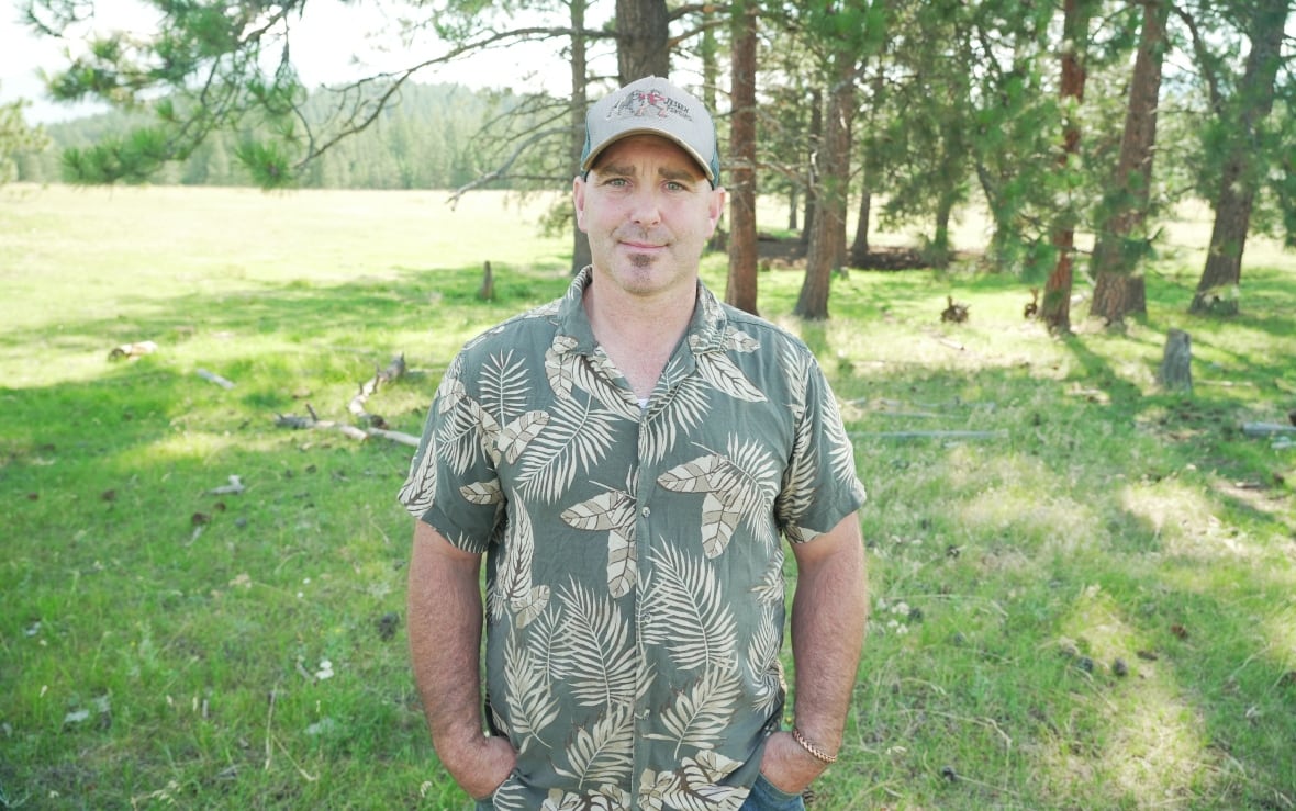A man wearing a Hawaiian shirt and a ball cap.