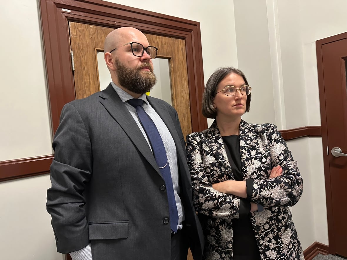 A man and a woman are shown by a door.