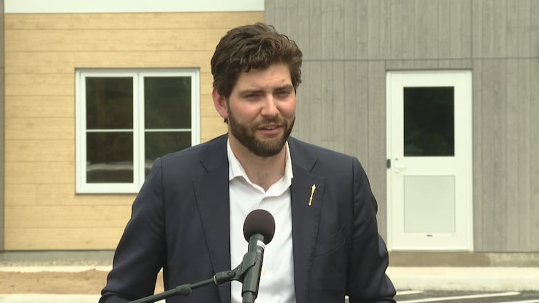 Man in suit in front of apartment building.