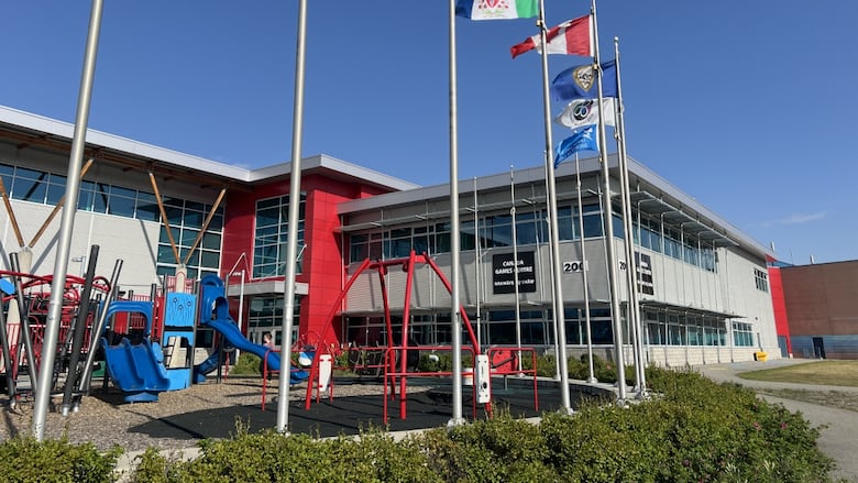 A large public building seen from the outside behind a row of flagpoles.