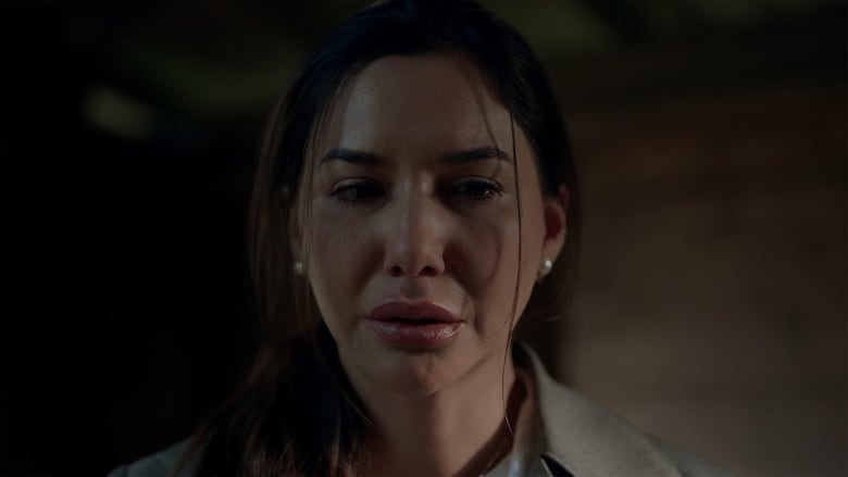 A young woman looks into the camera, distraught.