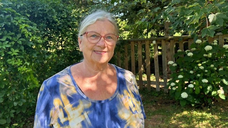 A woman in a blue and yellow shirt standing outside