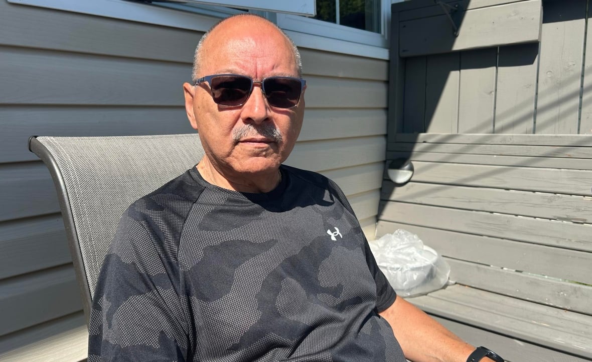 A man in sunglasses siting on a deck