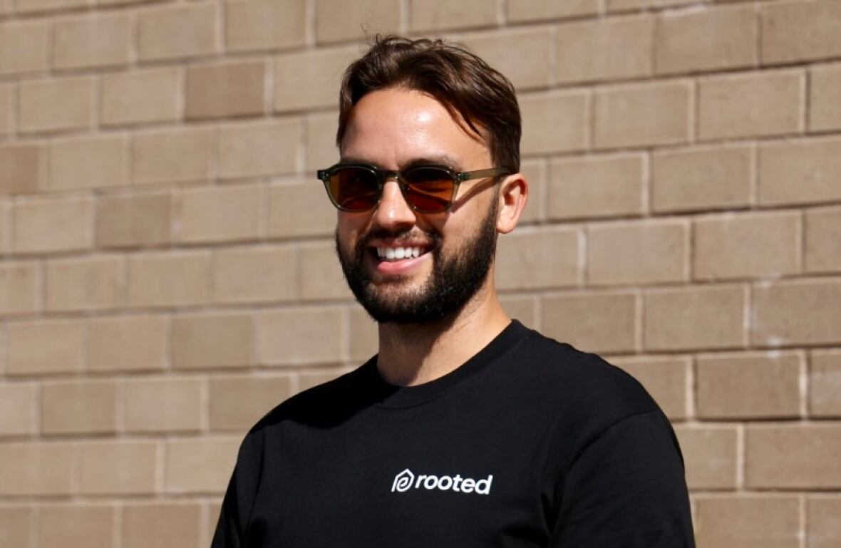 A man in sunglasses smiles at the camera.
