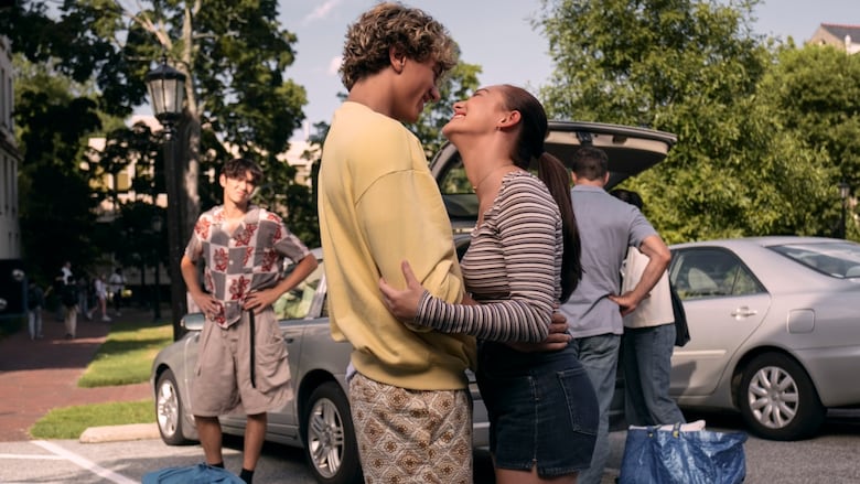 A boy and girl look up at each other and hug.