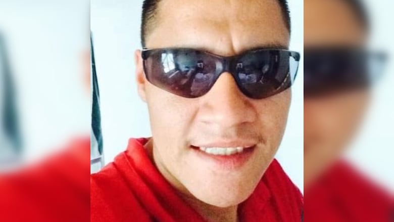 A man in sunglasses smiles.