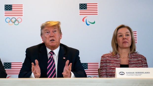 Two people sit on a dais.