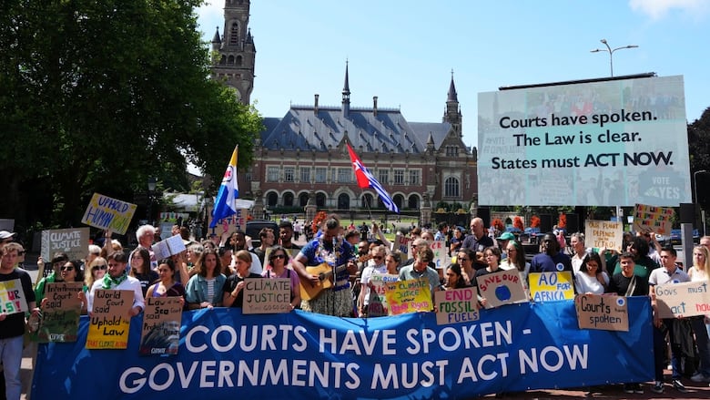 People hold banners in front of a building with many towers