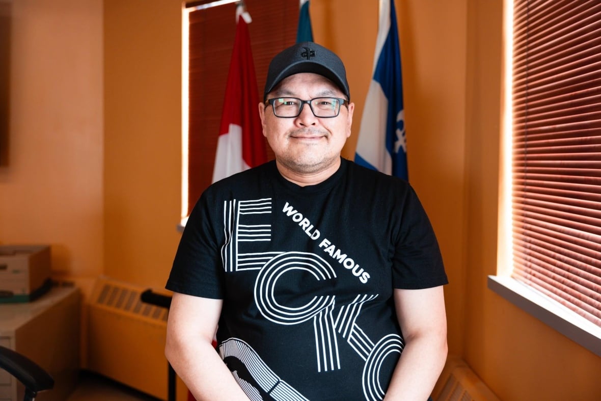 Man in t-shirt looks at camera.