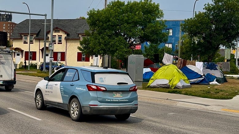 Tents set up next to a busy road