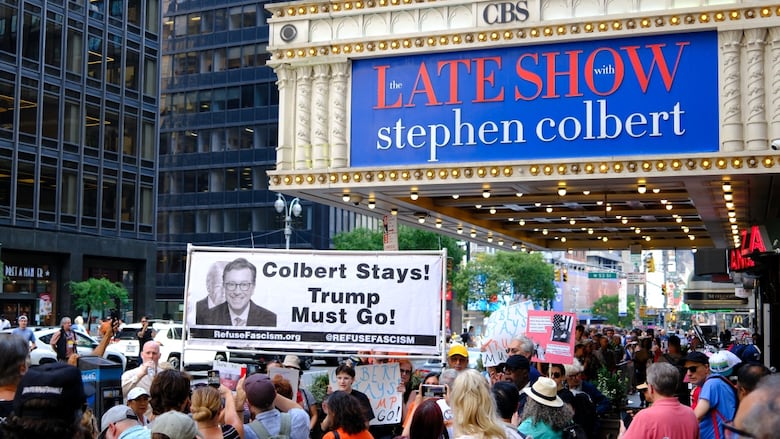 People participate in a protest titled 'Colbert stays! Trump must go!' outside the Ed Sullivan Theater in New York City on July 21, 2025. 
