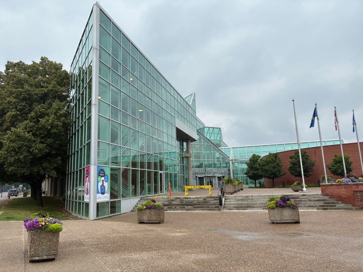A glass municipal building with a sharp, angled corner in the front.