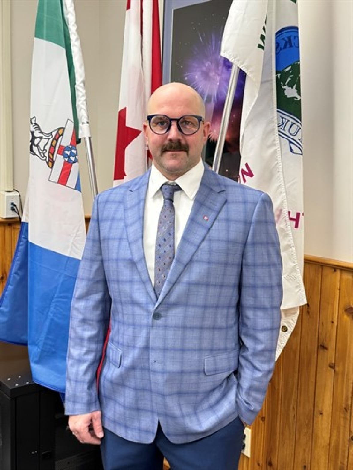 A man in a blue suit and glasses.
