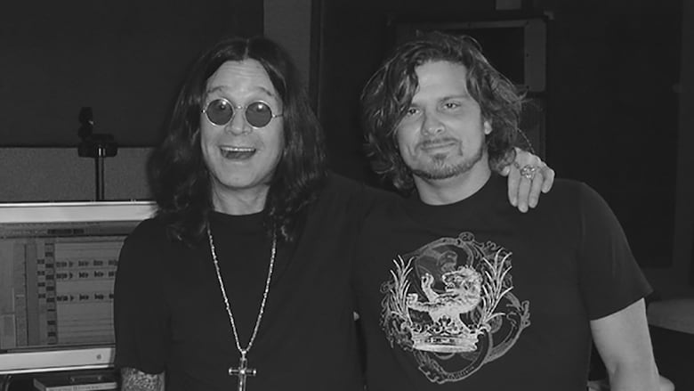 Two men stand side by side wearing t-shirts.