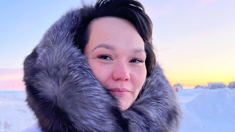 Woman in parka looks at camera