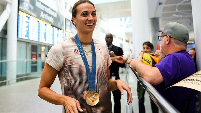Canadian Olympic medallist Kylie Masse signs autographs for swimming fans after arriving at Pearson airport in Toronto on August 12, 2024 following the Paris Olympic Games.