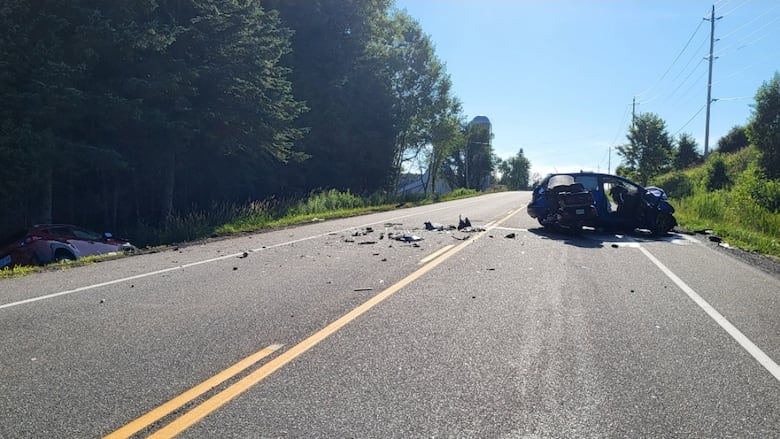 A scene of a collision on a rural road during the day.