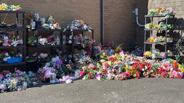A wall of silk flowers and trinkets removed from graves at a LaSalle cemetery.